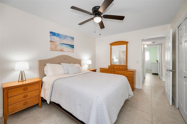 tiled bedroom featuring ceiling fan, a closet, and a textured ceiling