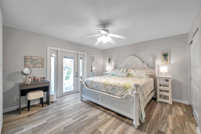 bedroom featuring ceiling fan, hardwood / wood-style floors, a textured ceiling, and access to outside