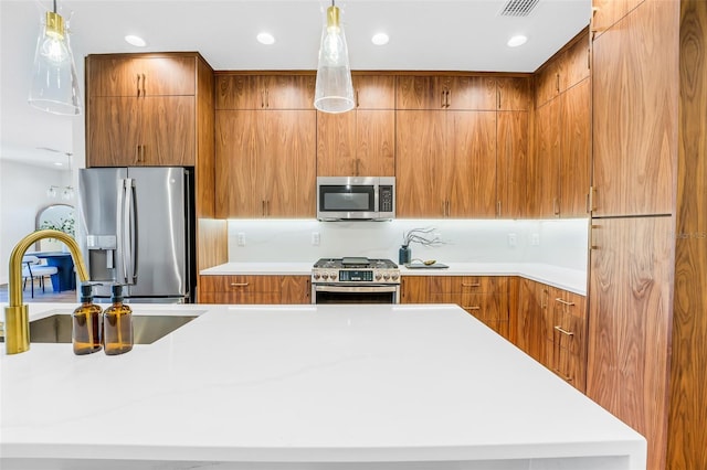 kitchen featuring sink, stainless steel appliances, and hanging light fixtures