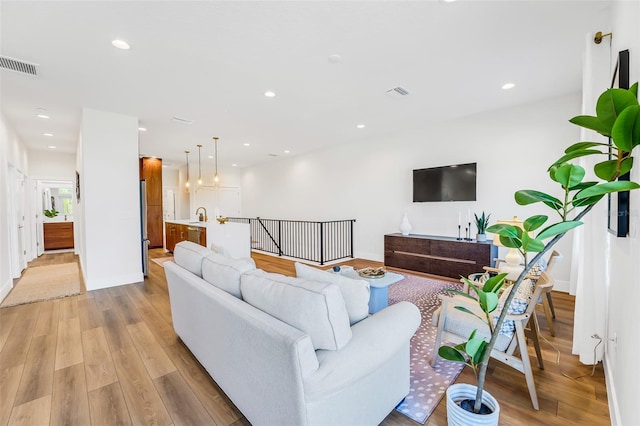 living room with sink and light hardwood / wood-style floors