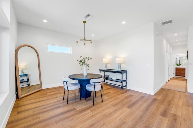 dining area featuring light hardwood / wood-style flooring and a chandelier