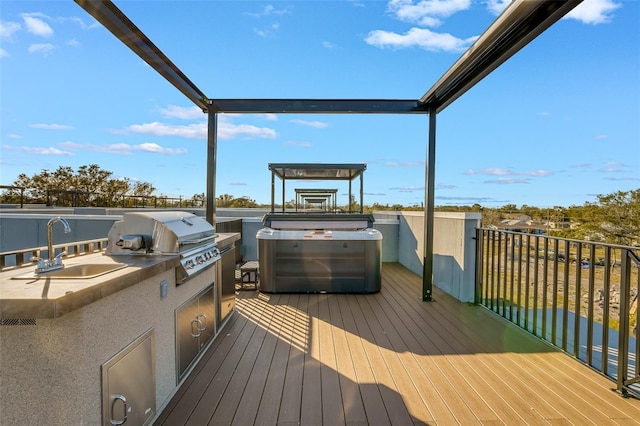 deck with exterior kitchen, a grill, and sink