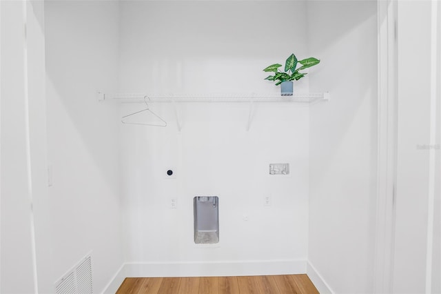 laundry room with electric dryer hookup and hardwood / wood-style flooring