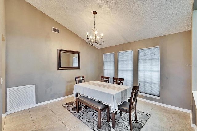 tiled dining area with vaulted ceiling, a textured ceiling, and a chandelier