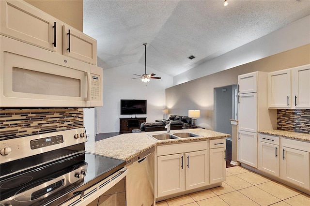 kitchen featuring sink, vaulted ceiling, appliances with stainless steel finishes, ceiling fan, and backsplash