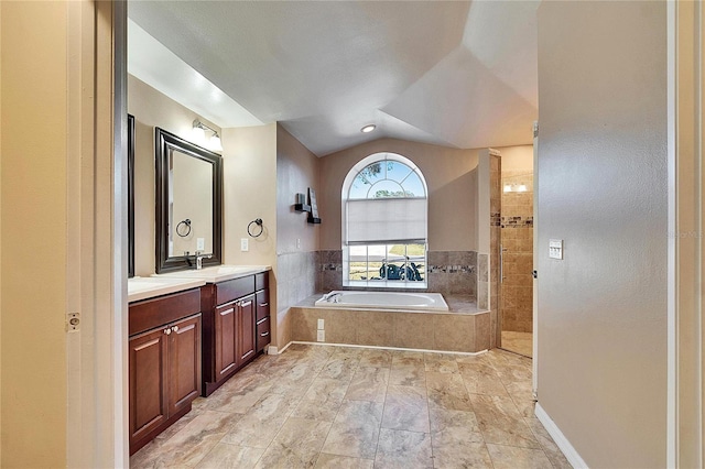 bathroom with lofted ceiling, vanity, and shower with separate bathtub