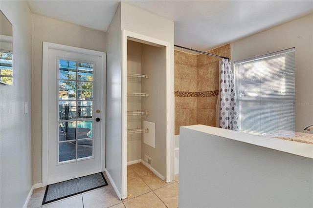 bathroom with a wealth of natural light, tile patterned floors, and shower / bath combo with shower curtain