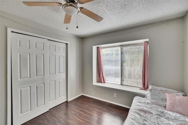 unfurnished room featuring dark wood-type flooring and a textured ceiling