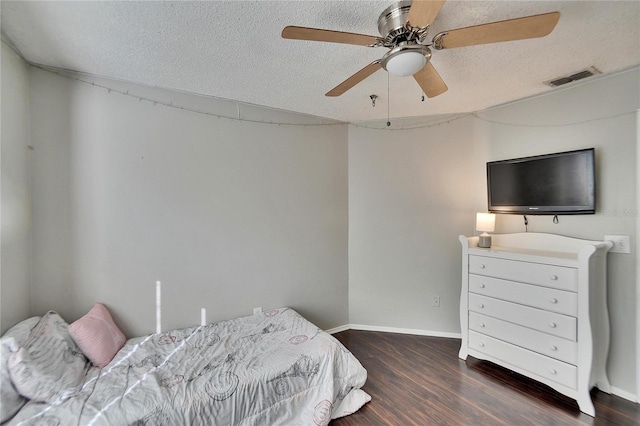 bedroom featuring dark hardwood / wood-style floors, a textured ceiling, and ceiling fan