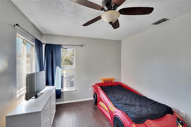 bedroom featuring a textured ceiling, dark wood-type flooring, and ceiling fan