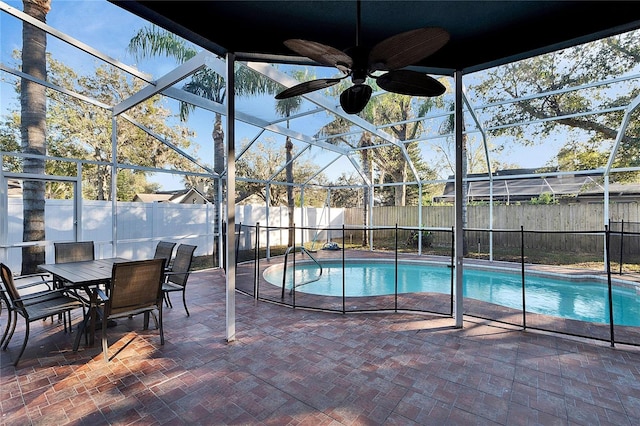 view of pool with ceiling fan, a patio, and glass enclosure