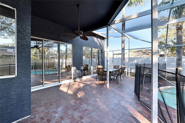 view of patio featuring ceiling fan, a fenced in pool, and glass enclosure