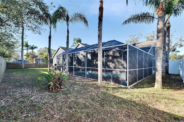 view of side of property featuring a lanai, a fenced in pool, and a lawn