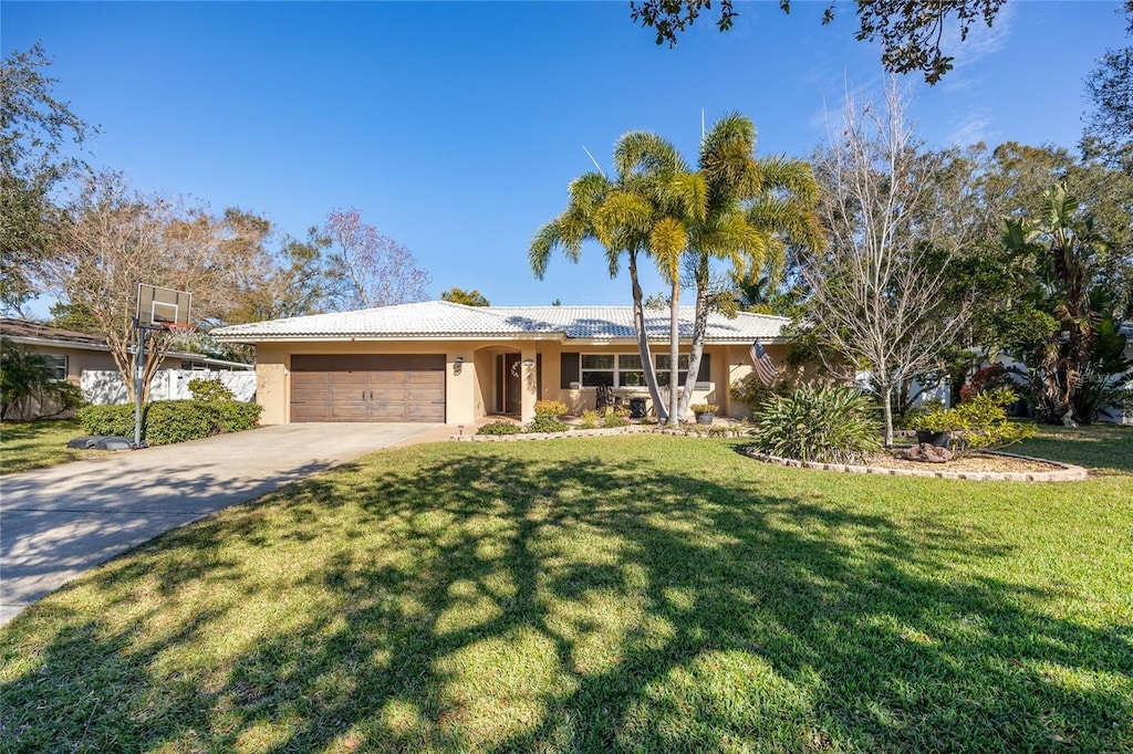 ranch-style home with a garage and a front lawn