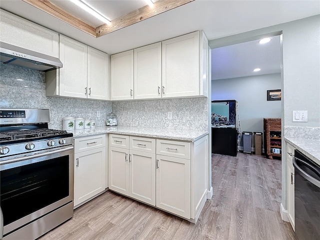 kitchen featuring white cabinetry, light stone counters, stainless steel range with gas stovetop, black dishwasher, and wall chimney range hood