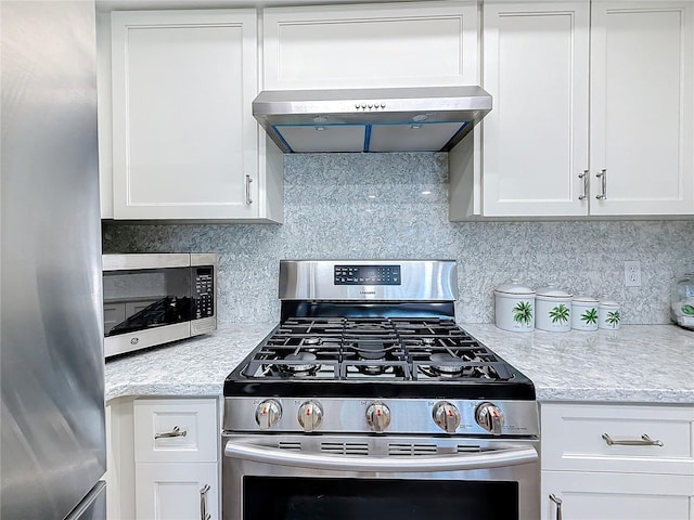 kitchen featuring appliances with stainless steel finishes, range hood, decorative backsplash, and white cabinets