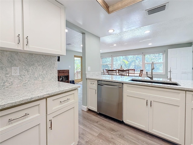 kitchen featuring sink, light hardwood / wood-style flooring, white cabinets, and dishwasher