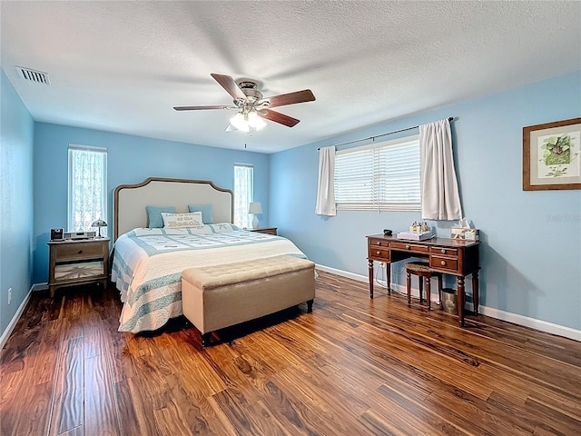 bedroom featuring ceiling fan, dark wood-type flooring, and a textured ceiling