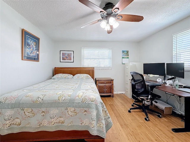 bedroom with wood-type flooring, ceiling fan, and a textured ceiling