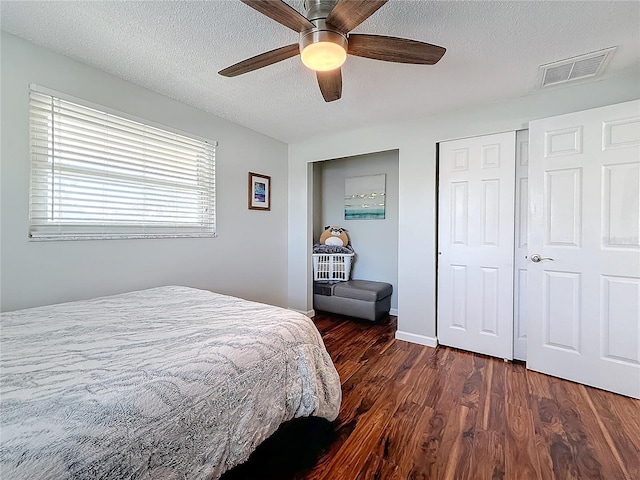 bedroom with dark hardwood / wood-style flooring, ceiling fan, a closet, and a textured ceiling