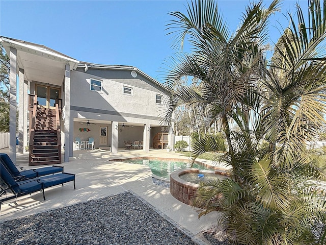 exterior space featuring a swimming pool with hot tub, a patio, and ceiling fan