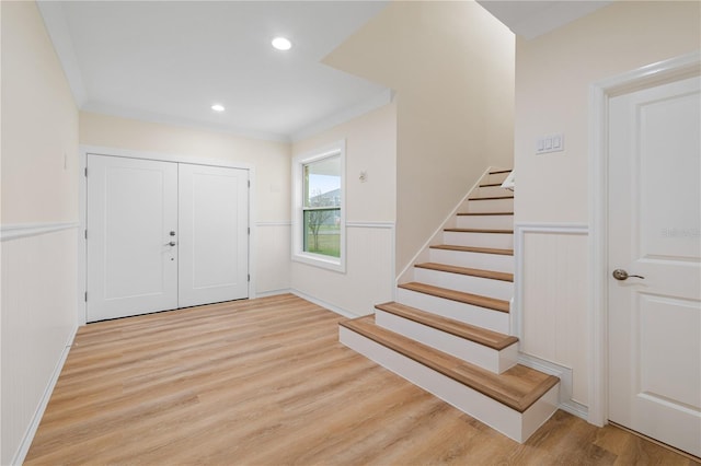 entryway featuring crown molding and light wood-type flooring