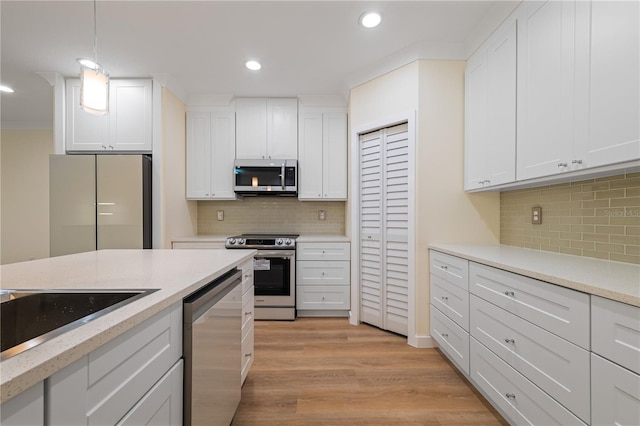 kitchen featuring white cabinetry, light hardwood / wood-style flooring, stainless steel appliances, and tasteful backsplash