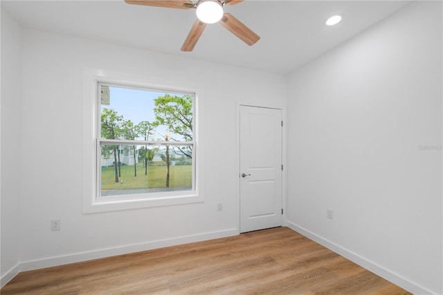 empty room with ceiling fan, a healthy amount of sunlight, and light wood-type flooring