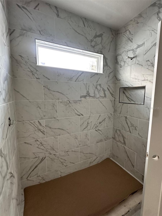 bathroom with a tile shower