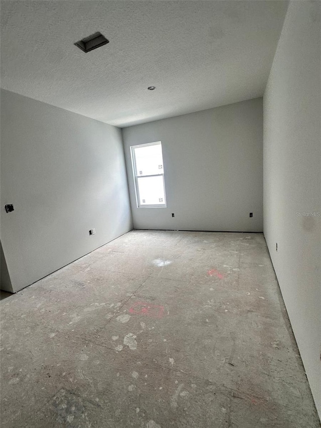 unfurnished room featuring a textured ceiling