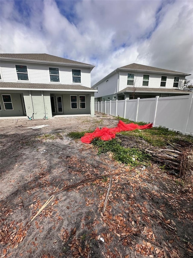 rear view of house with fence and a patio