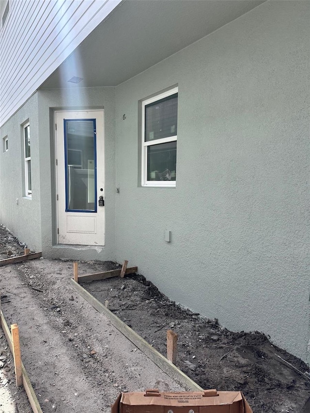 view of exterior entry with stucco siding