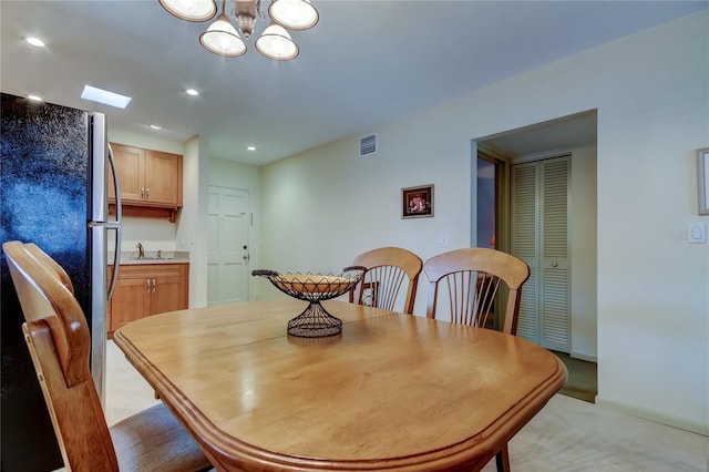 dining space featuring sink and a chandelier