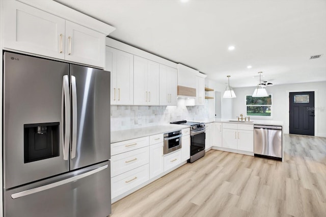 kitchen with decorative light fixtures, sink, white cabinets, backsplash, and stainless steel appliances