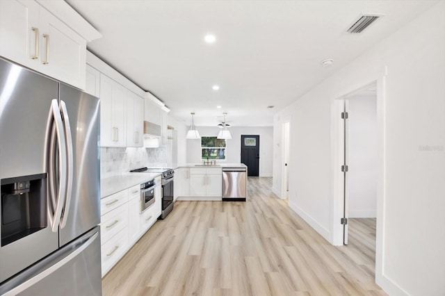 kitchen with sink, appliances with stainless steel finishes, backsplash, white cabinets, and decorative light fixtures