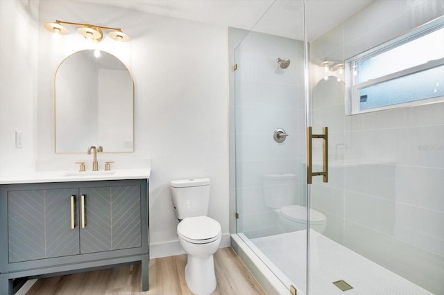 bathroom featuring vanity, toilet, a shower with shower door, and wood-type flooring