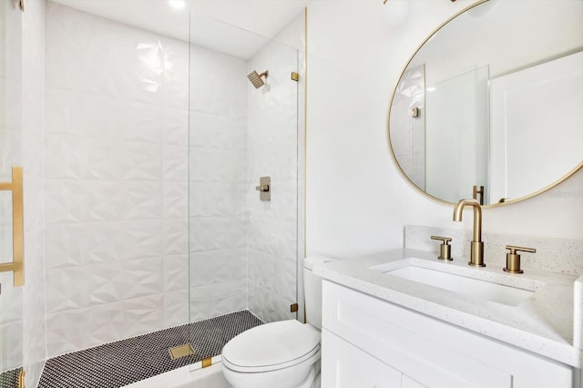 bathroom featuring vanity, toilet, and tiled shower