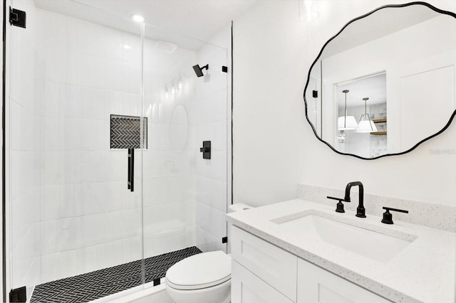 bathroom with a shower with door, vanity, and toilet