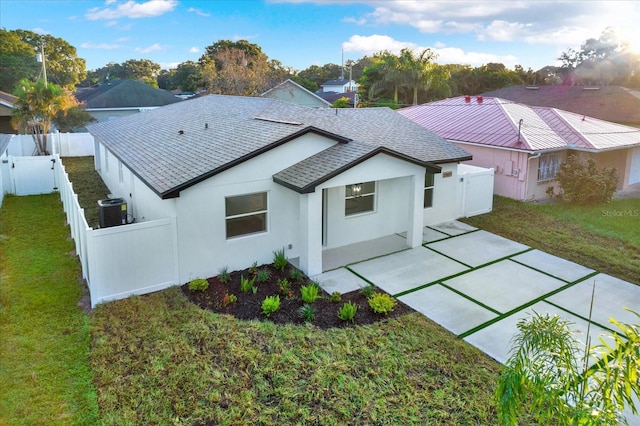 rear view of property featuring a yard, a patio, and central air condition unit