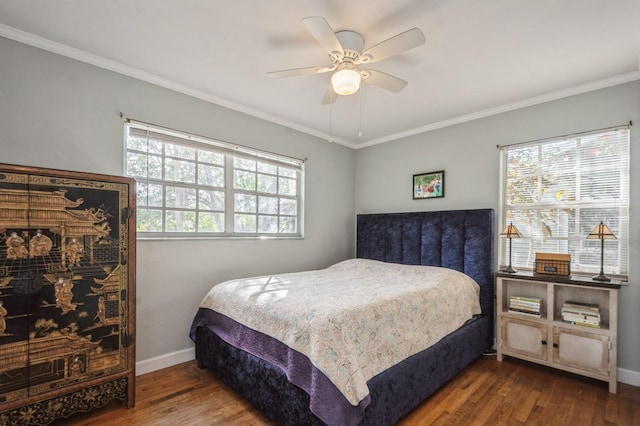 bedroom featuring multiple windows, hardwood / wood-style flooring, and ornamental molding