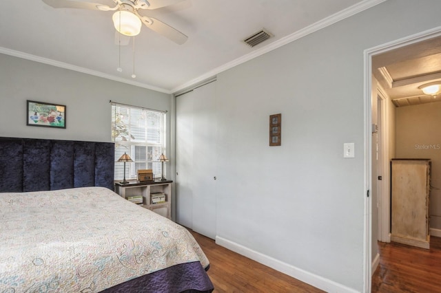 bedroom with ornamental molding, ceiling fan, dark hardwood / wood-style flooring, and a closet