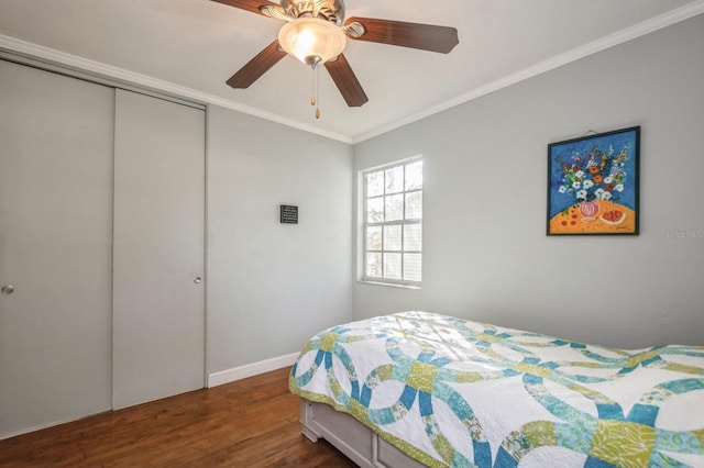 bedroom with ornamental molding, ceiling fan, dark hardwood / wood-style flooring, and a closet