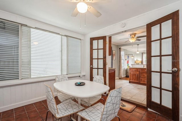 tiled dining area with lofted ceiling and ceiling fan