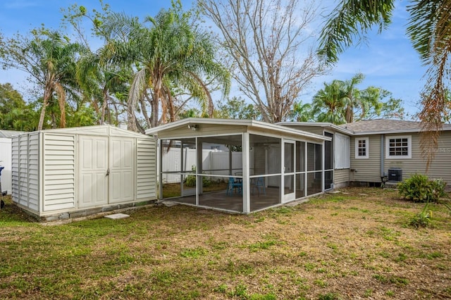 rear view of house with cooling unit, a sunroom, a lawn, and a patio area