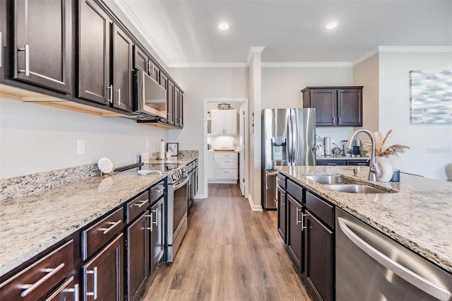 kitchen featuring sink, crown molding, dark brown cabinets, stainless steel appliances, and hardwood / wood-style floors