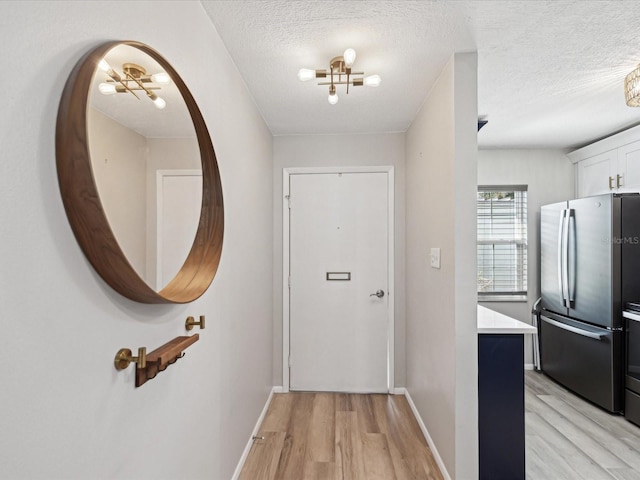 corridor featuring light hardwood / wood-style floors and a textured ceiling