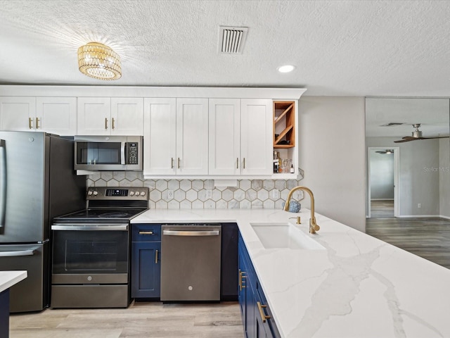 kitchen featuring white cabinetry, sink, stainless steel appliances, and blue cabinetry