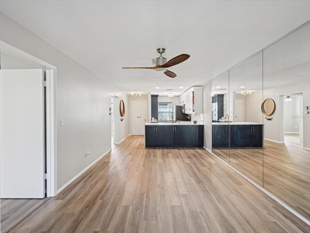 kitchen featuring decorative light fixtures, white cabinets, ceiling fan, kitchen peninsula, and light wood-type flooring