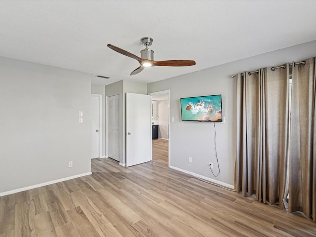 unfurnished bedroom with light wood-type flooring, ceiling fan, and a closet