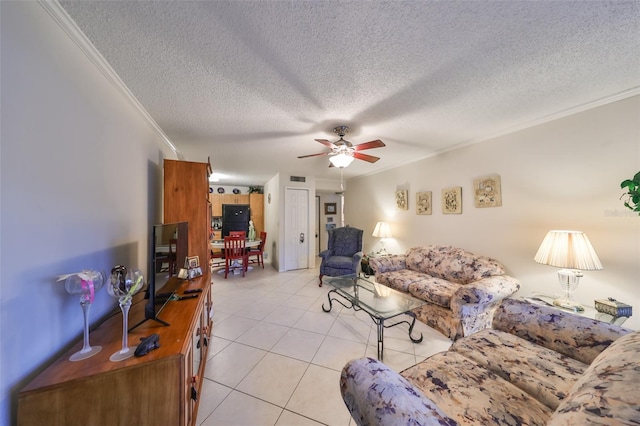 living room with ceiling fan, ornamental molding, a textured ceiling, and light tile patterned floors